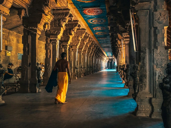 man in brown thobe walking on hallway